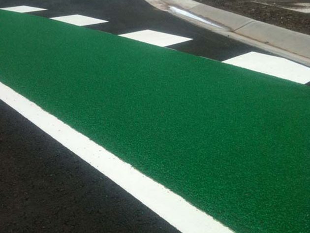 A green anti-skid coloured surface laid along a cycle lane, with a white edge line beside it
