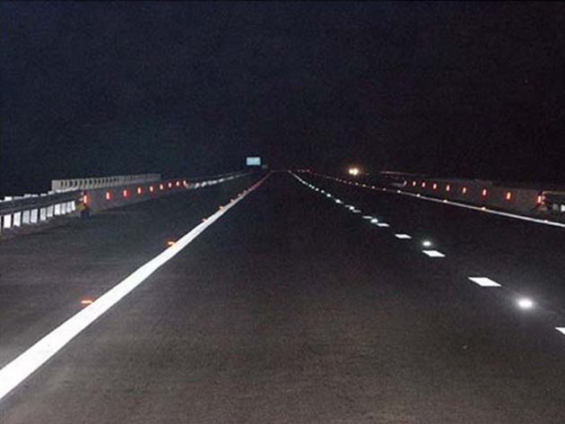 White road lines and reflective markers on a road photographed at night